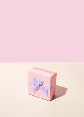 Pink gift box with velvet bow. Pastel background.