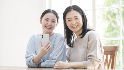 Fototapeta premium 一緒にスマホを見る二人の女性