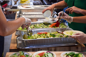 Women volunteers filling up plates with food at community event