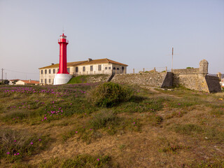 Fototapeta na wymiar The Farol de Esposende (Esposende Lighthouse) set in front of the Fort of Sao Joao Baptista de Esposende is situated at the mouth of Cavado river, north of Portugal.