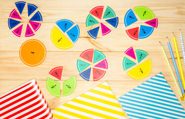 Multicolored wooden fractions, notepads on wooden table. Trendy puzzle toys. Geometric shapes. Back...