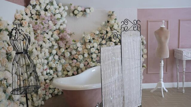 The bath stands in the corner of the room decorated with flowers. A beautiful place for body care