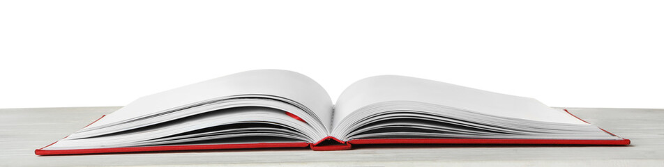 Open book with red cover on wooden table against white background