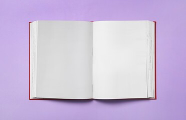 Open book with blank pages on violet background, top view. Space for text