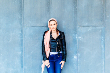 portrait of a woman leaning against a wall in the street pink companion in symbol of the fight...