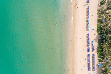 Aerial view from flying drone of people crowd relaxing on beach and swimming in beautiful tropical summer sea at Phuket island Thailand, Top View beautiful dreamy beach