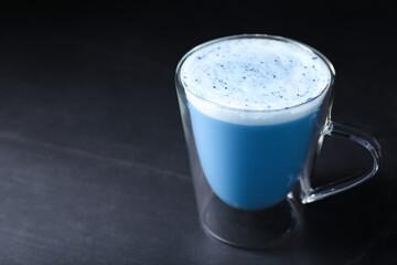 Delicious blue matcha latte on black table. Space for text