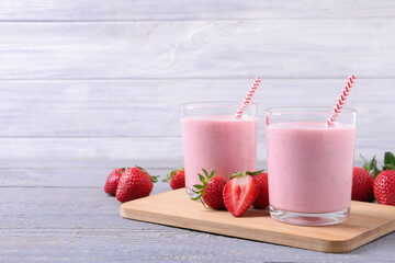 Delicious strawberry drink on light grey wooden table. Space for text