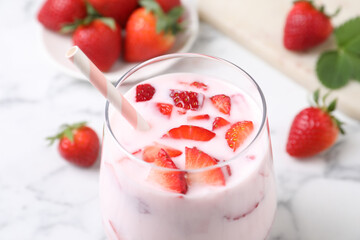 Delicious drink with strawberries on white marble table, closeup