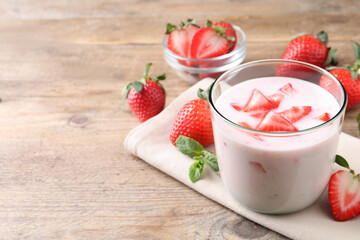 Delicious drink with strawberries on wooden table, space for text