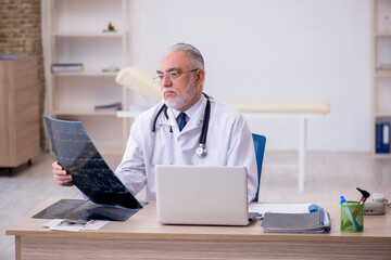 Old male doctor radiologist working in the clinic