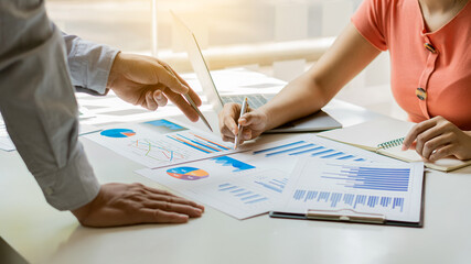 A businessman sits at the graph analysis desk. On graphics and charts with office calculators