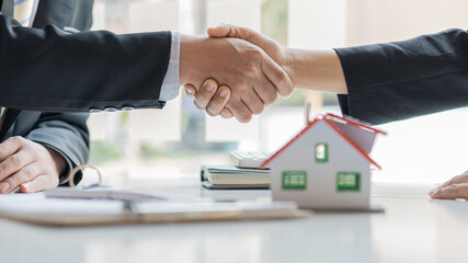 Fototapeta na wymiar Real estate agents and clients shake hands after the deal is done on the home purchase and rental concept.