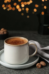 Delicious coffee with nutmegs on grey table