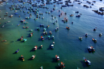 Fototapeta na wymiar Fishing boats in a harbor during a sunny day, aerial view