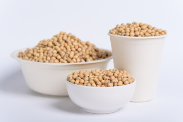 Soybean seeds in a bowl and cup on white background