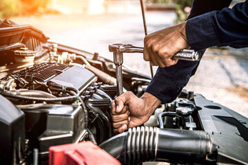 Car maintenance, Close-up hands of auto mechanic are using the wrench to repairing car engine is problems at auto repair garage. Concepts of car care check and fixed and services insurance.