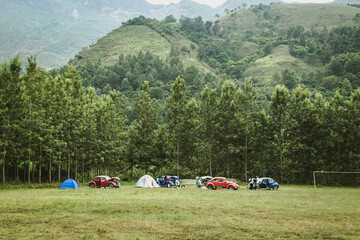 parked cars and people enjoying a camping day in nature