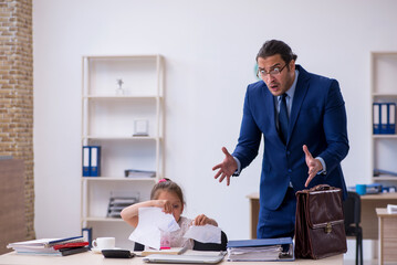 Young male employee and his little girl in the office