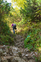 Female hiker climbing steep trail in Romanian Carpathians