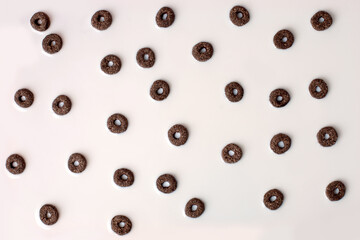 A lot of black rings cerial in white milk, breakfast background. Crispy corn in milk, flyer, banner for text, copy space, Concept of breakfast fast products