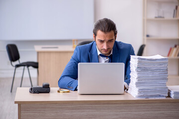 Young male employee and too much work in the office