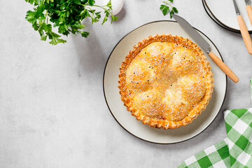 Freshly baked a showstopping raised pie using sausagemeat and boiled eggs on light gray background, top view. Space for text