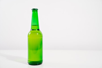 green glass bottle on a white background. condensate