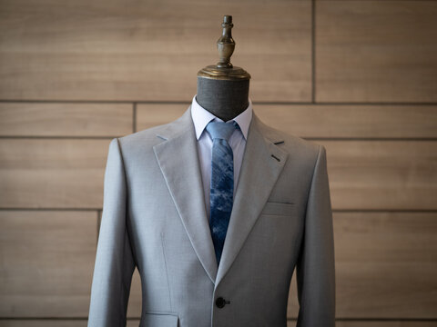Close up of light grey with ticket pocket suit jacket  with blue shirt white collar detail 