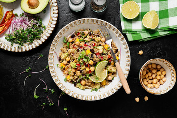 Healthy quinoa black bean salad with mango and avocado. Perfect for spring, summer, fall or winter. Black stone background, top view.	
