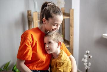 Mother and child wearing in bright clothes are tenderly hugging each other. Concept of a happy...
