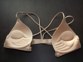 beige bra with front closure on black background. High quality photo