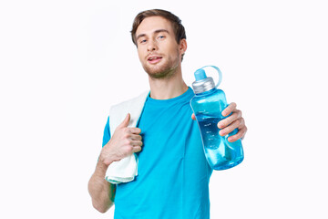 sporty man in blue t-shirt water bottle towels workout