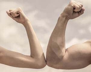 Obraz na płótnie Canvas Muscular arm vs weak hand. Vs, fight hard. Competition, strength comparison. Rivalry concept. Hand, man arm fist Close-up. Rivalry, vs, challenge, strength comparison. Sporty man and woman