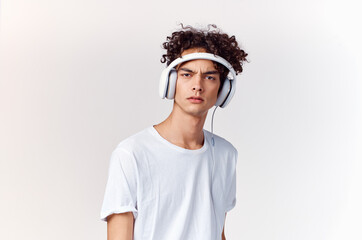 young man with headphones listening to music new technology white t-shirt light background