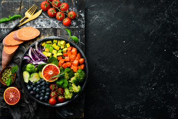 Vegan Buddha Bowl: Sweet Potatoes, Blueberries, Avocados, Cabbage and Orange. Dietary food. Top view. Free space for your text.