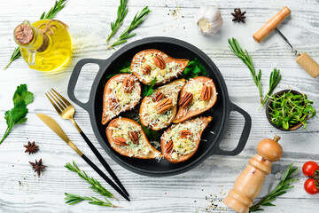 Baked pears with blue cheese and nuts. In a frying pan. Rustic style. Flat Lay.