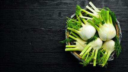 Fresh organic fennel bulbs in a wooden box. Healthy food. Top view. Free space for your text. - obrazy, fototapety, plakaty