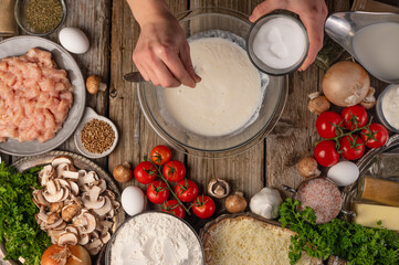 Fototapeta premium chef prepares kneading dough, ingredients background.On old wooden table, cooking pizza or pie, top view flat lay