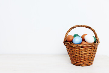 easter holiday with colored eggs in a basket light background 