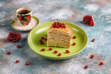 Delicious homemade crepe cake decorated with pomegranate seeds and mandarins.