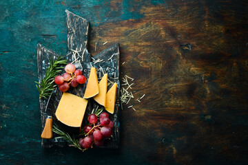 Hard aged cheese on a plate with snacks. Rustic style. Free copy space.