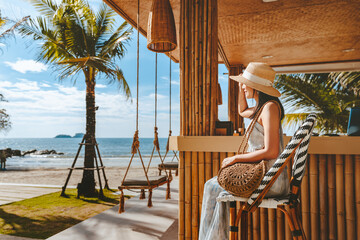 Traveler asian woman travel and relax on swing in beach cafe at Koh chang summer Thailand - obrazy, fototapety, plakaty