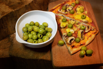 pizza with olives on a wooden board
