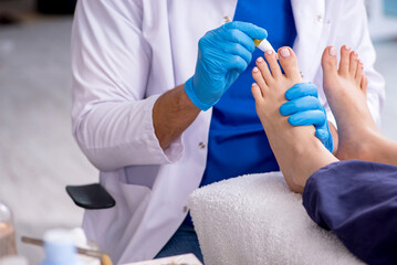Podiatrist treating feet during procedure