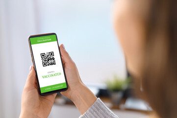 The smartphone screen with an international covid passport in hand of a woman, coronavirus...