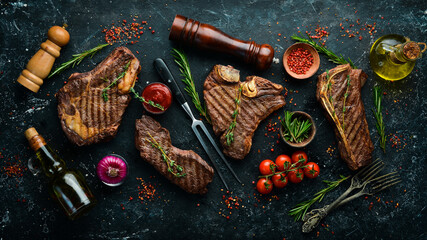 Steak menu. Juicy grilled steaks on a black stone background: t-bone, striploin, Rib eye, new york...