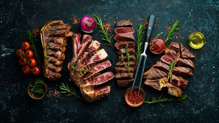 Steak menu. Sliced steaks on a black stone background: t-bone, striploin, Rib eye, new york steak....