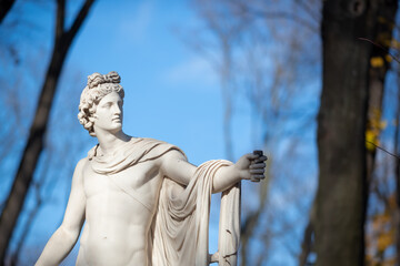 Beautiful antique statue of Apollo in the autumn park. A copy of an ancient sculpture. The ancient...