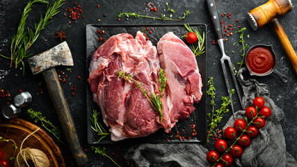 Piece of fresh raw pork from the neck, with ingredients and spices on a kitchen background. Meat. Top view. Rustic style.
